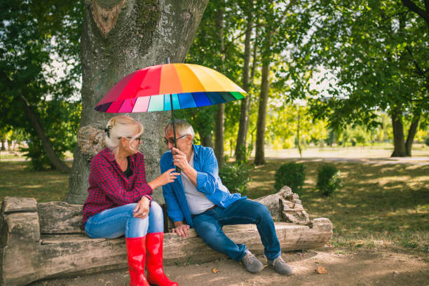 The old couple in the rain with umbrellas