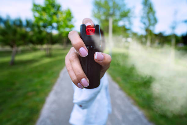 Woman using pepper spray or tear gas for self defence outdoors. High quality photo