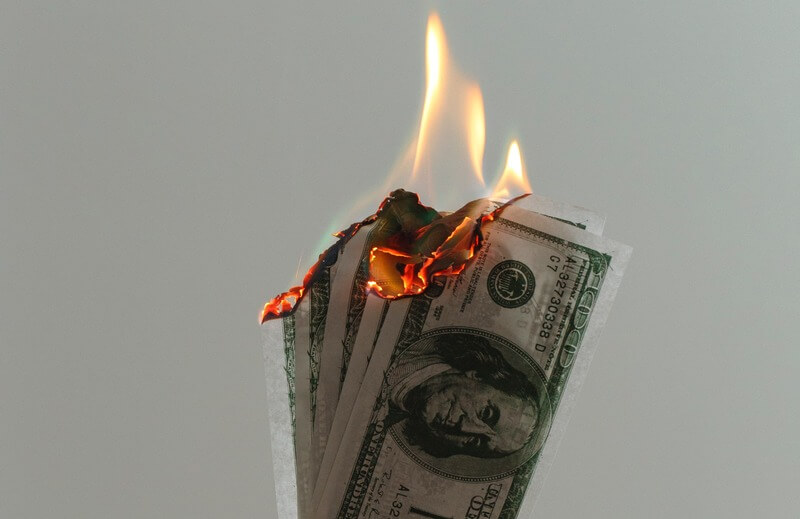 time lapse photography of several burning US dollar banknotes