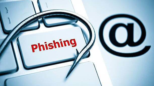 phishing / a fish hook on computer keyboard with email sign / computer crime / data theft / cyber crime