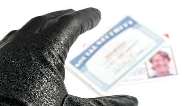 A gloved hand reaches for a social security card and id card.