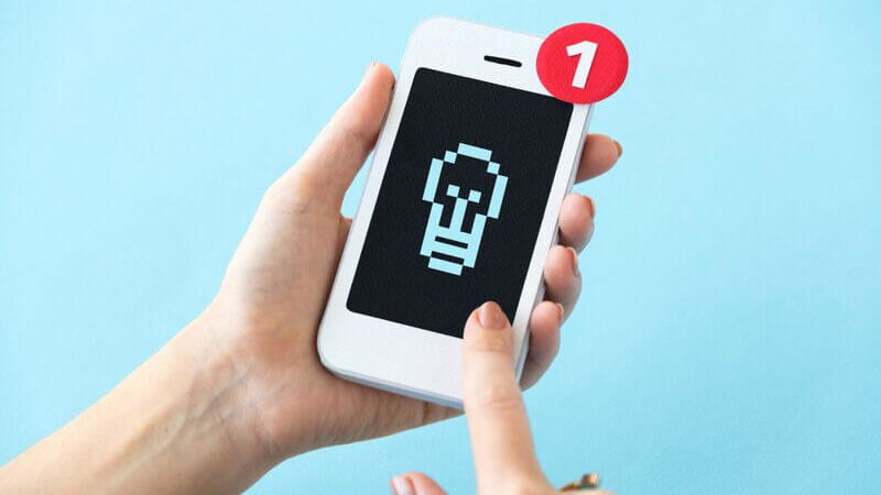 Closeup of hands holding paper craft mobile phone mockup